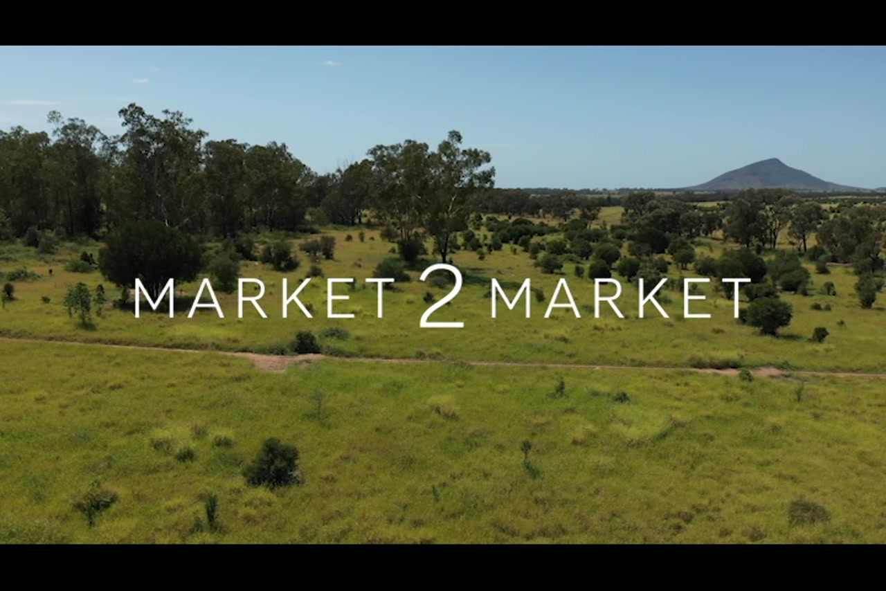 Aerial footage tracking along with quad bike on dirt road in rural country landscape